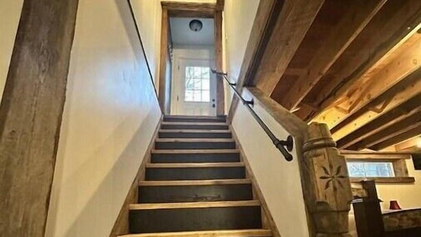 A wooden staircase with a handrail leading to a door at the top. - A Country Stay Just Minutes Away
 (Cambridge)