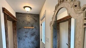 A hallway with a textured wall, a wooden floor, and a large ornate mirror on the right. - A Country Stay Just Minutes Away
 (Cambridge)