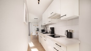 Une cuisine moderne avec des meubles blancs, une cuisinière Bosch et une machine à café.
