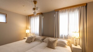 A hotel room with a large bed, two bedside tables with lamps, and a ceiling fan. - Tsutenkaku Royal House (Osaka)