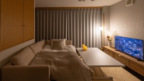 A modern bedroom with a bed, a TV, and a nightstand. - Tsutenkaku Royal House (Osaka)
