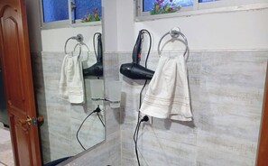 A bathroom with a mirror, two hair dryers, and a towel rack. - Charming Family Retreat in the Heart of Bogotá (Bogotá)