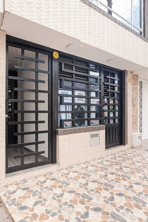 A building with a tiled entrance and a black gate. - Charming Family Retreat in the Heart of Bogotá (Bogotá)