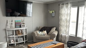 Ein Wohnzimmer mit Sofa, Couchtisch, Fernseher und Bücherregal.