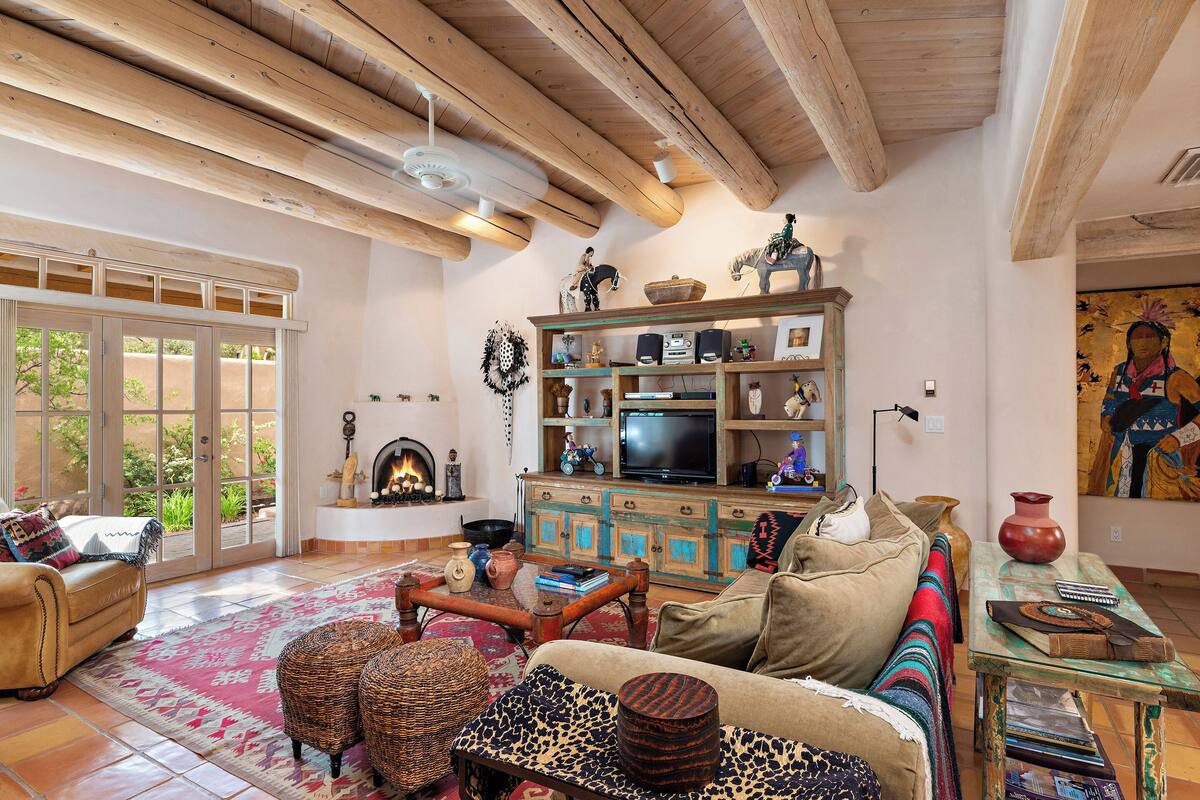 A living room with a sofa, a coffee table, a television, and a fireplace.