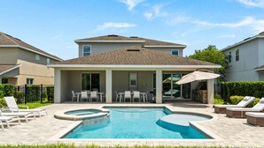 A residential backyard with a swimming pool, lounge chairs, and a covered patio area. - 8 Bedrooms/ 8 Bathrooms/ Encore (7714FD) (Kissimmee)