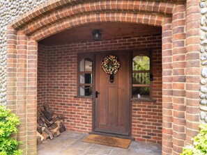 A brick house entrance with a wooden door, a welcome mat, and a wreath. - Perfect for family and friends get togethers to enjoy coast and countryside. (Walpole St Peter, near King&rsquo;s Lynn)