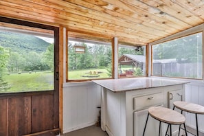 A kitchen with a large window, wooden ceiling, and a view of a green landscape. - Home w/ Hot Tub! 5 Mins from Hunter Mtn (Lanesville)