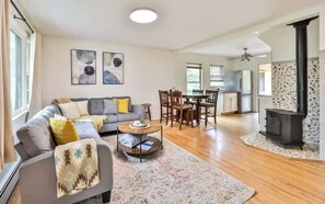 A modern living room with a sofa, coffee table, and dining area. - Home w/ Hot Tub! 5 Mins from Hunter Mtn (Lanesville)