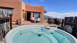A hot tub in a backyard with a patio, chairs, and a mountain view. - Adobe Tranquillo Mountain Views (El Prado)