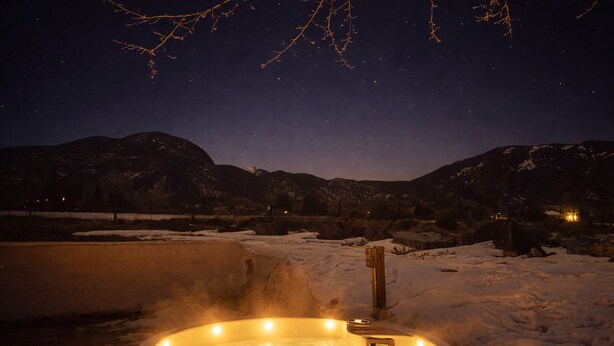 A hot tub surrounded by snow with mountains in the background. - La Querencia - Taos Foothills Comfort (Arroyo Seco)
