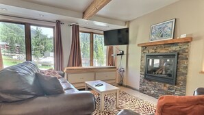 Una sala de estar con sofá, mesa de centro y chimenea.
