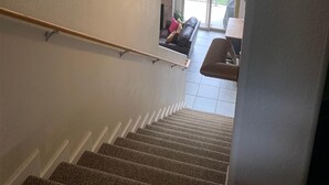 Una escalera que conduce a un balcón con vistas a un bosque.