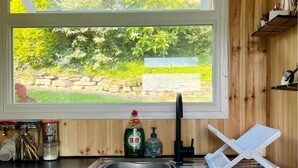 Una cocina con ventana, un lavabo y un escurreplatos.
