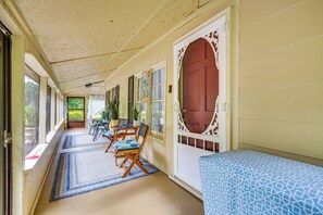 A covered porch with a dining table and chairs, a bench, and a door with decorative glass panels. - Lakeview Vacation Rental - Walk to Crystal Lake! (Lakeview)
