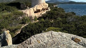 A stone tower on a rocky outcrop with a view of the sea and distant mountains. - A 10 mn des Plages, Appartement Refait à Neuf au Cœur D'un Village Authentique (Monacia-d'Aullène)