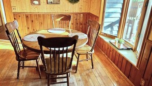 A wooden dining room with a round table and four chairs. - Cozy 3 b/r home w/ quick access to snowmobile trails in the beautiful Northwoods (Minocqua)