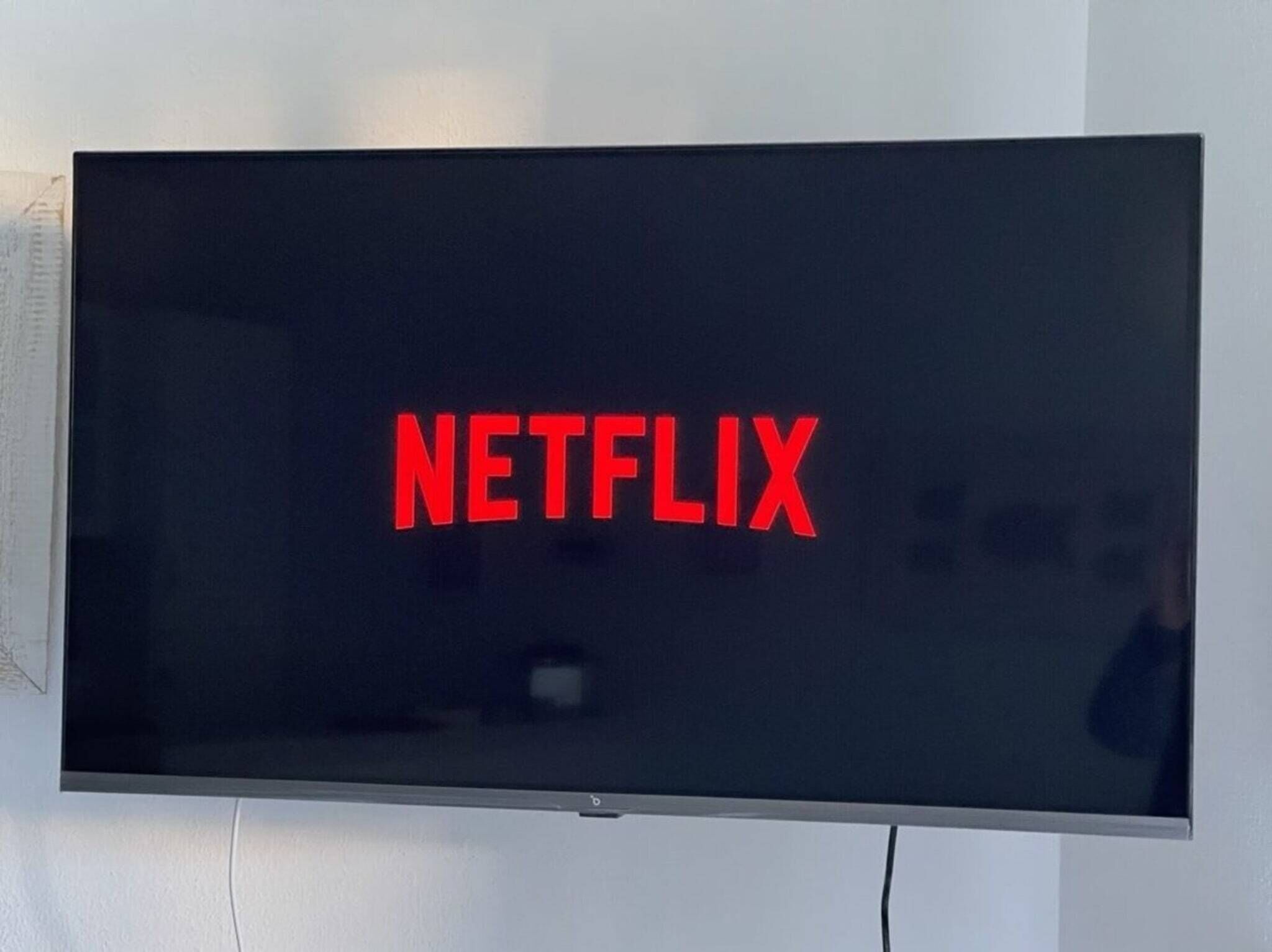 Un téléviseur à écran plat dont l’écran affiche le logo de Netflix.