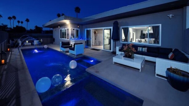 Une maison moderne dotée d’une piscine, d’un espace extérieur aménagé et d’un intérieur bien éclairé.