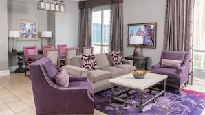 A living room with a sofa, armchairs, a coffee table, and a dining area with chairs and a table. - Wyndham Grand Desert 2 BR Deluxe - Full Resort Access 1 Mile of Vegas Strip! (Las Vegas)
