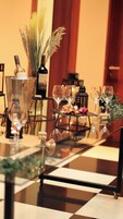 Una mesa a cuadros con copas de vino, botellas y una vela.