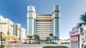 A large, modern hotel with a central tower and multiple balconies. - Boardwalk Resort: Ocean Breeze Retreat (Myrtle Beach)