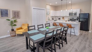 A modern kitchen with white cabinets, a black refrigerator, and a central island. - Beautiful Fenced 3BR 2BA Near Exciting Downtown (San Antonio)