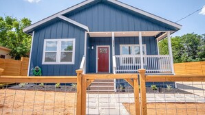A two-story blue house with a front porch, a red door, and a number 841 on the wall. - Beautiful Fenced 3BR 2BA Near Exciting Downtown (San Antonio)