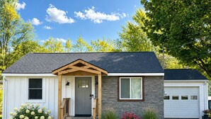 A single-story house with a front porch, a garage, and a well-maintained lawn. - Cozy Modern Utica Retreat 2BD • Private Home • Near Hospital, Downtown & Dining (Utica)