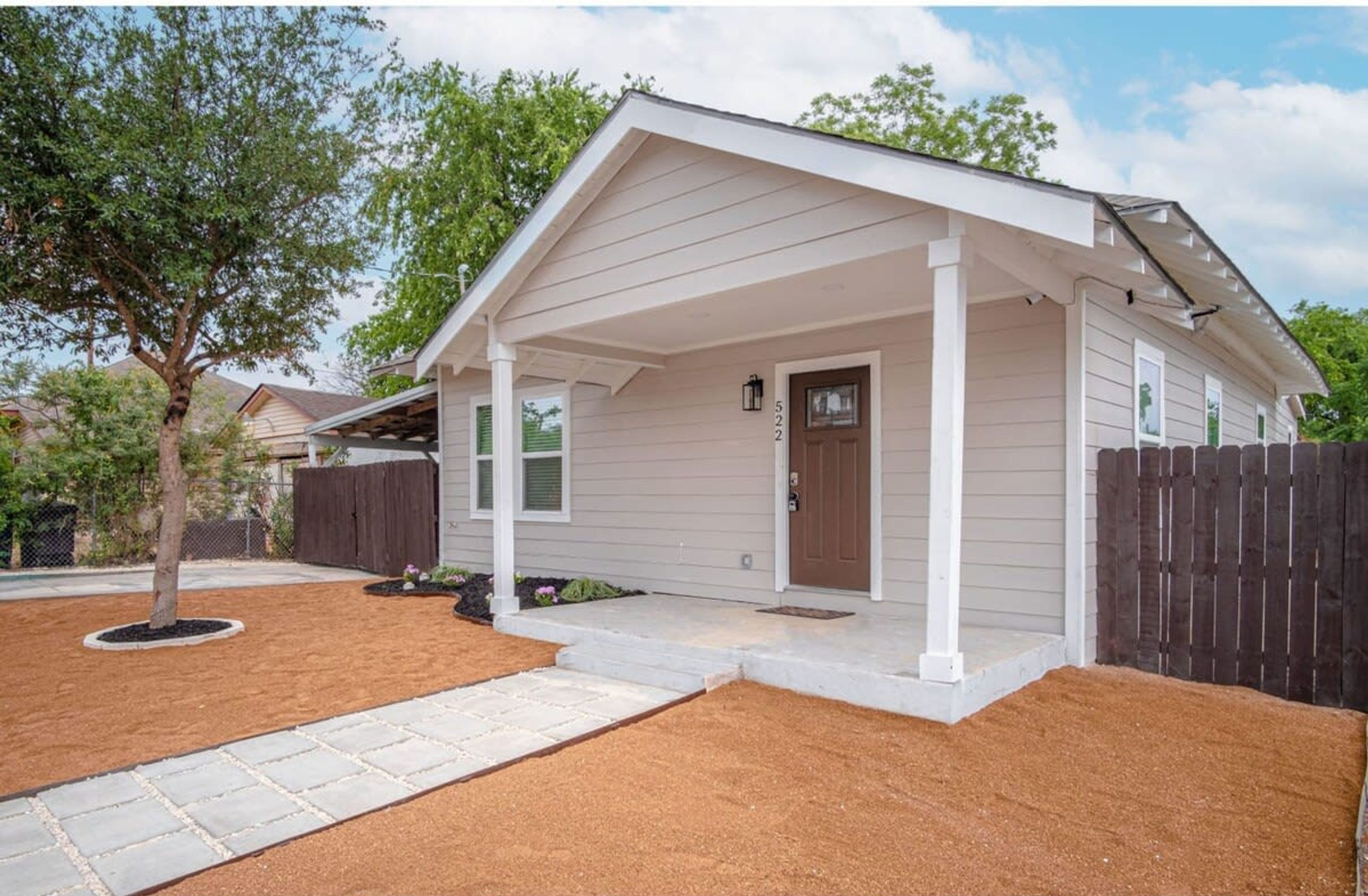 A single-story house with a covered porch, a front door, and a mailbox.