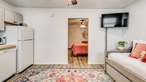 A compact living space with a kitchenette, a bed, a TV, and a ceiling fan. - OSU Weekend Retreat - Steps to Campus (Stillwater)