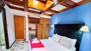 A simple hotel room with a bed, a nightstand, a wardrobe, and a small kitchenette. - Hotel Mariscal Robledo Cartago  (Cartago)