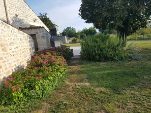 A stone building with a garden in front.