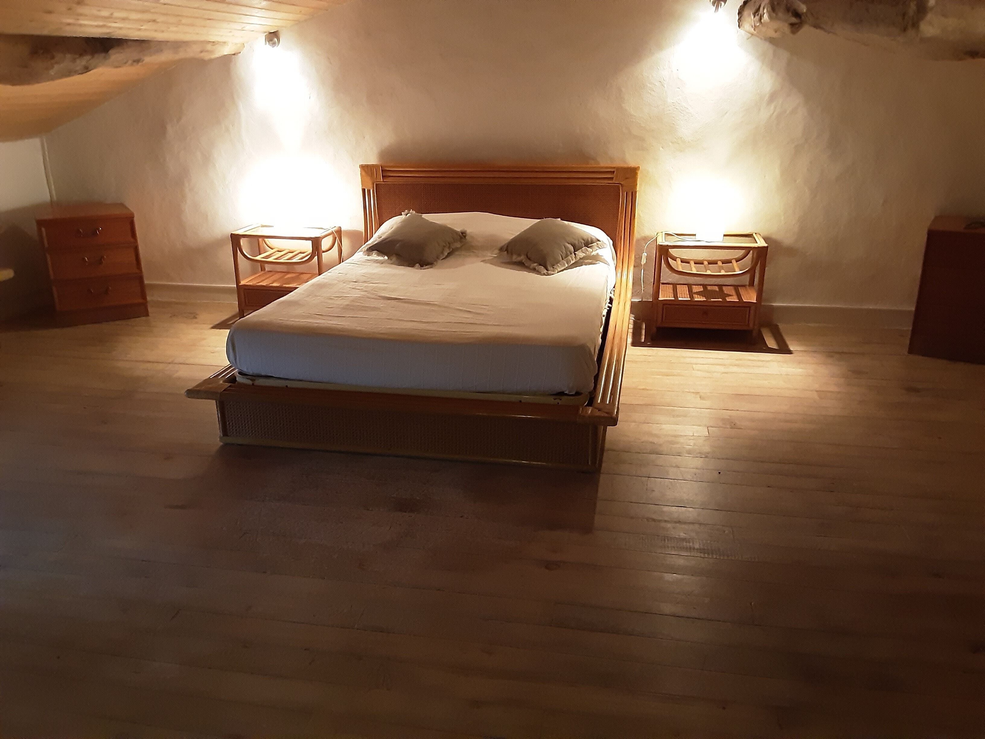 A wooden bed with a headboard, two bedside tables, and a nightstand.