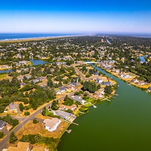 An aerial view of a residential area with houses, a river, and a bridge.