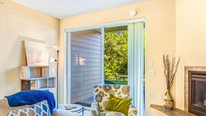 A living room with a sofa, armchair, and a fireplace. - Dune Buggy Condo in Ocean Shores (Ocean Shores)