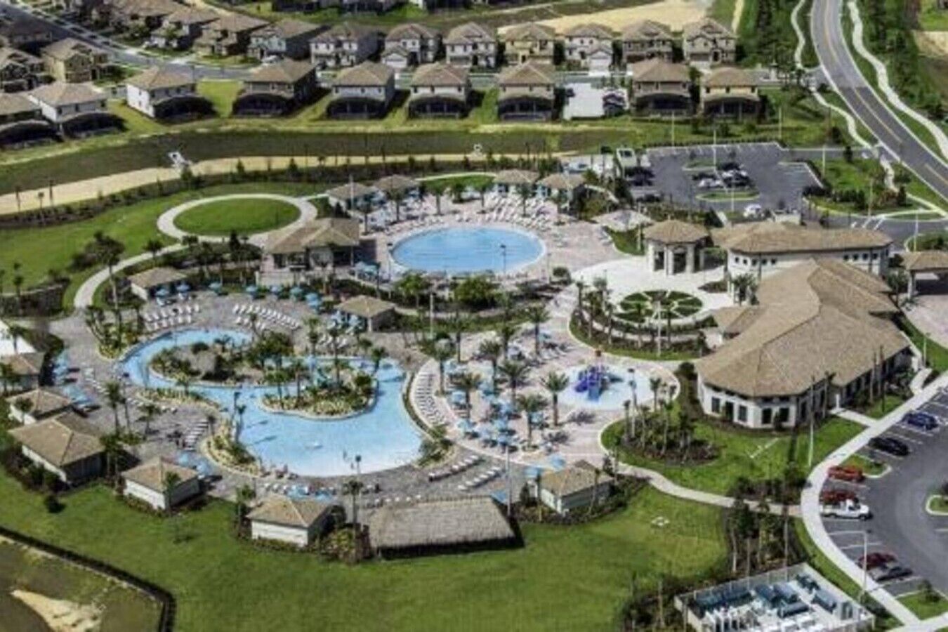 A resort with multiple swimming pools, a central courtyard, and surrounding villas.