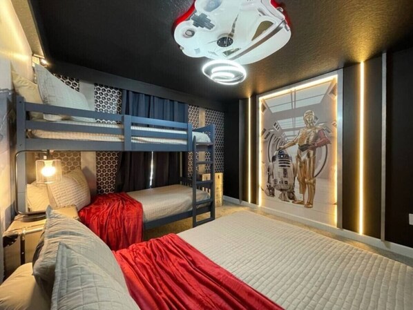 A bunk bed room with a Star Wars themed wall art and a ceiling light fixture.