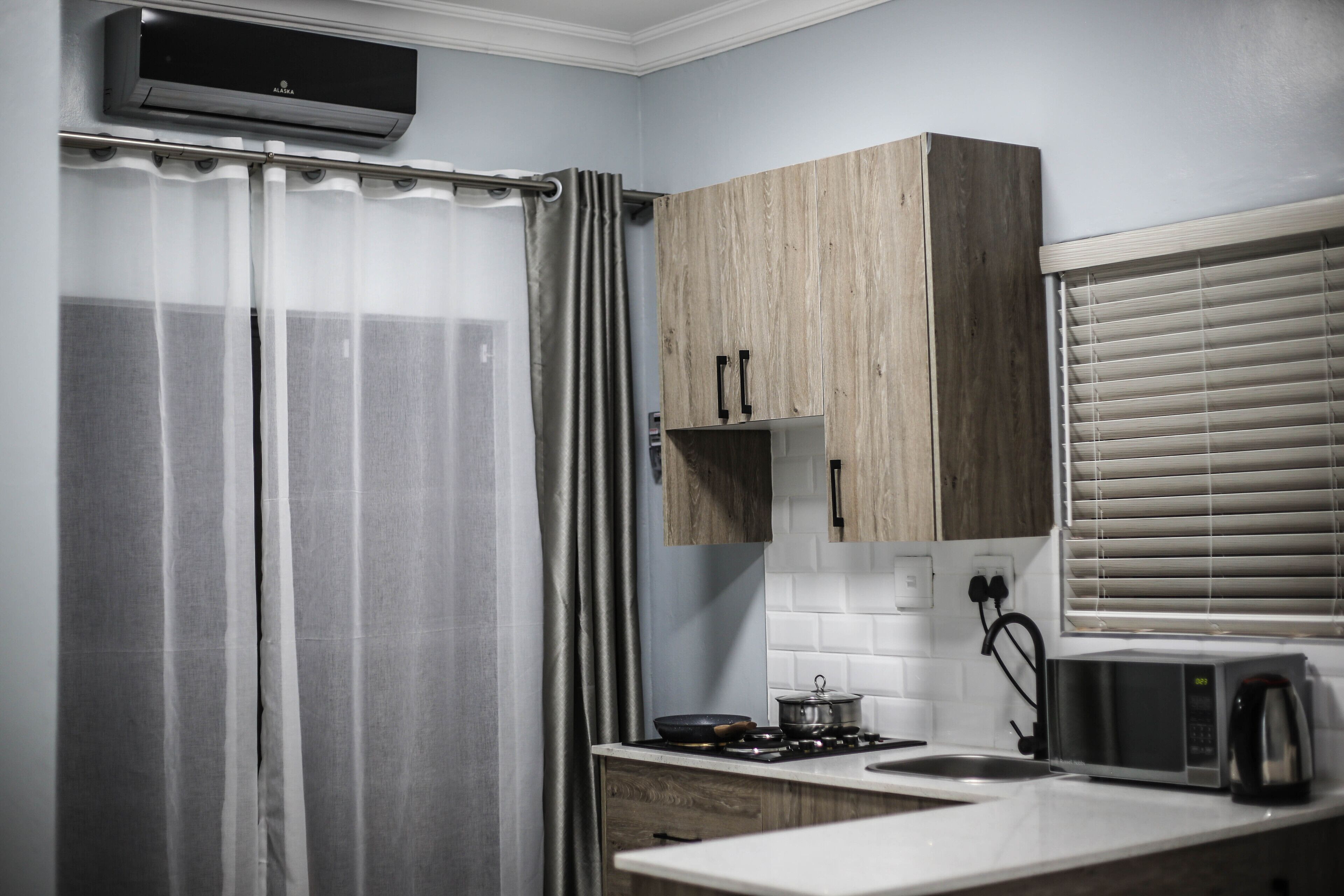 A kitchen with a microwave, stove, and wooden cabinets.