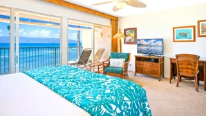 A hotel room with a balcony, a bed, a TV, and a desk. - Lokelani Resort by KBM (Napili-Honokowai)