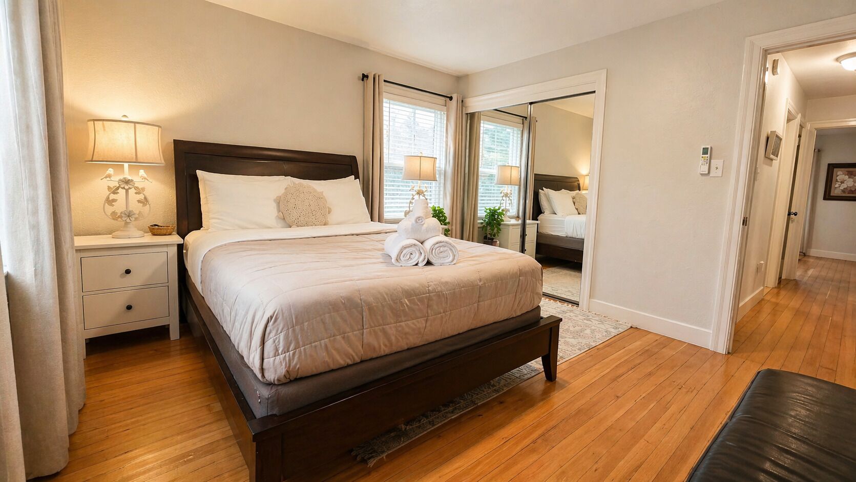 Une chambre à coucher avec un lit, des tables de chevet, une lampe et un miroir.