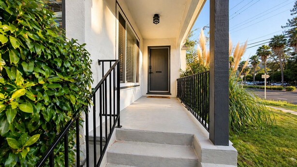 A residential building with a front porch, a door, and a staircase leading to the entrance. - Spacious 3BR Home - Near Downtown Martinez (Martinez)