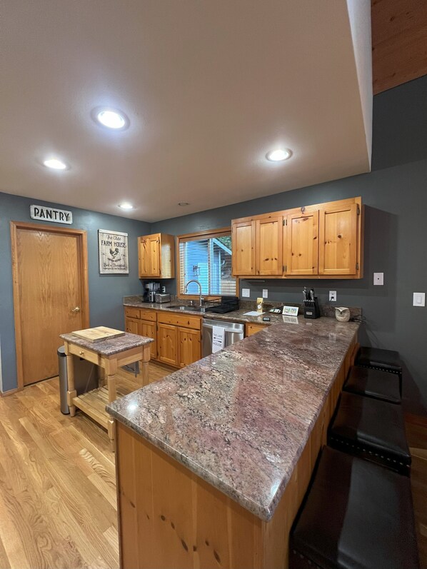 A kitchen with wooden cabinets, a granite countertop, and a sign indicating 'The Lake House'.