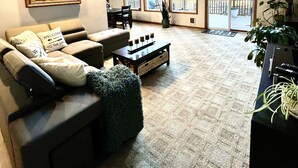 A spacious living room with a high ceiling, large windows, a fireplace, and a cozy seating area. - Beautiful lakefront Casa del Lago on Lake Roesiger (Snohomish)