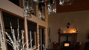 A dining area with a table set for a meal, decorative glassware, and a fireplace in the background. - Beautiful lakefront Casa del Lago on Lake Roesiger (Snohomish)