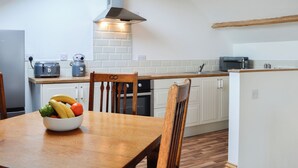A modern kitchen with white cabinets, a wooden ceiling, and a skylight. - 2 bedroom accommodation in Ruthwell, near Annan (Ruthwell, near Annan)