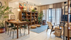 Uma sala de estar com área de jantar, estante de livros e televisão.