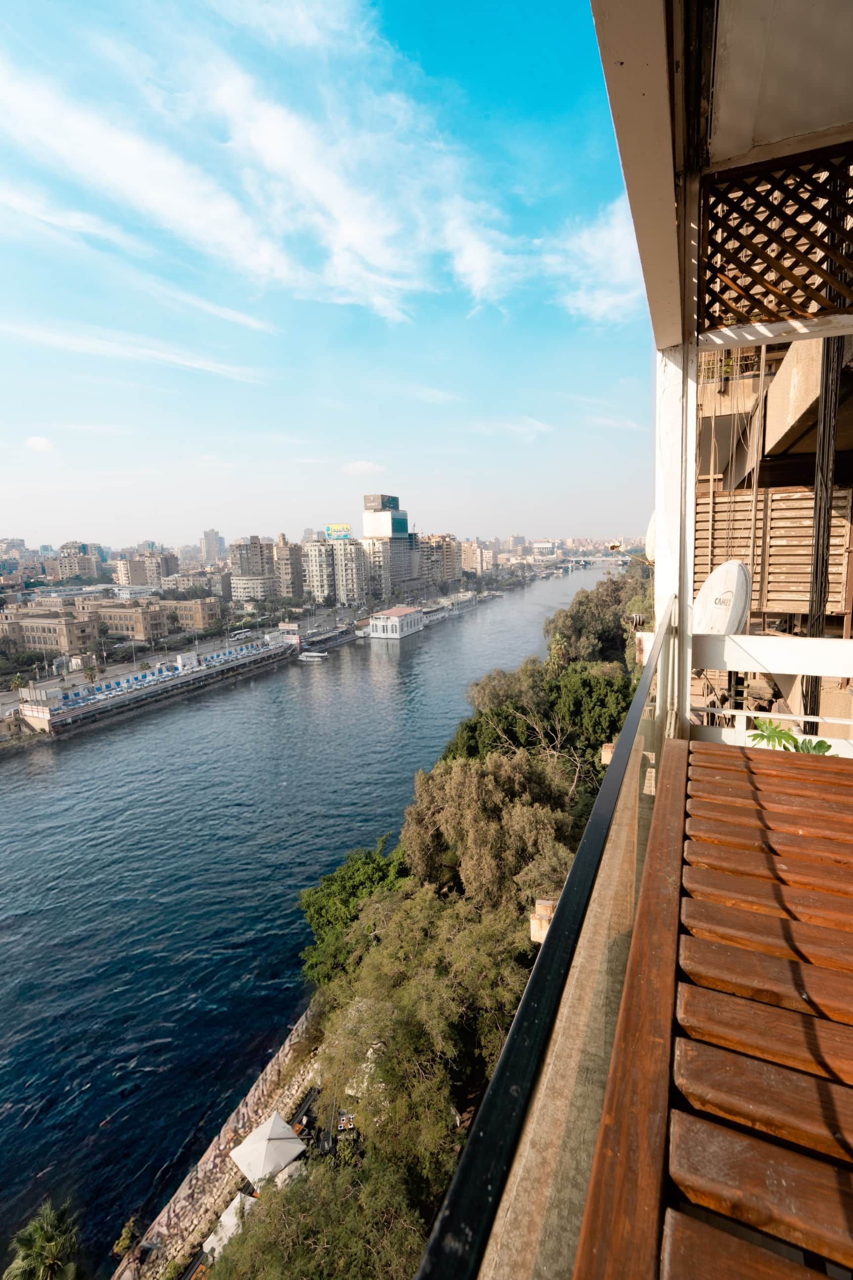 Un balcón con vista a un río, edificios de la ciudad y un puente.