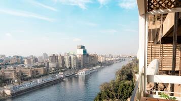 Un balcón con vista a un río, edificios de la ciudad y un puente.