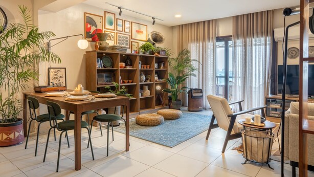 Ein Wohnzimmer mit Essbereich, Bücherregal und Fernseher.